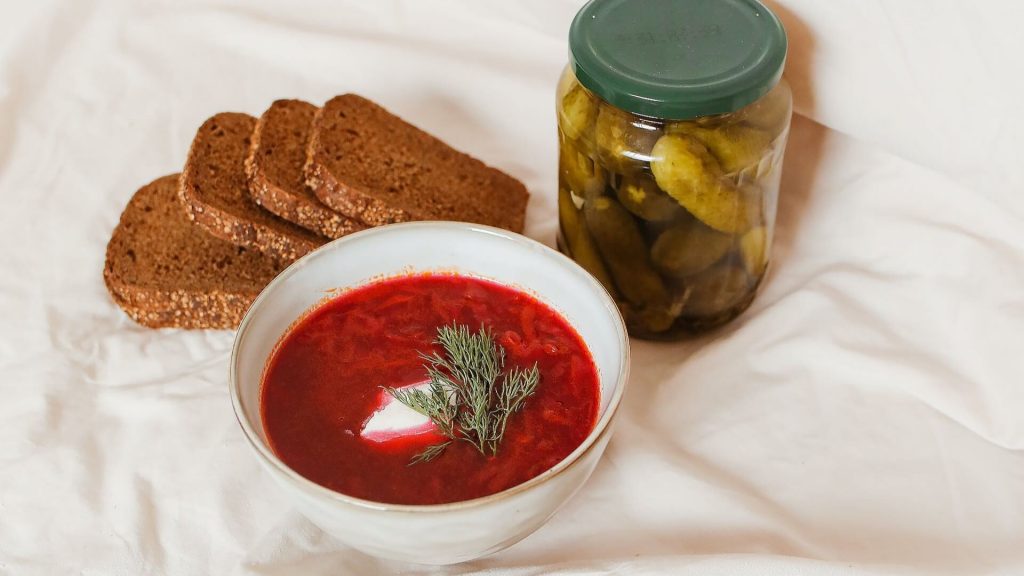 A comforting borscht, a soup made with beets and accompanied by pickles and bread